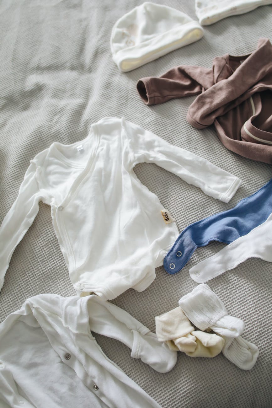 baby clothes arranged on bed