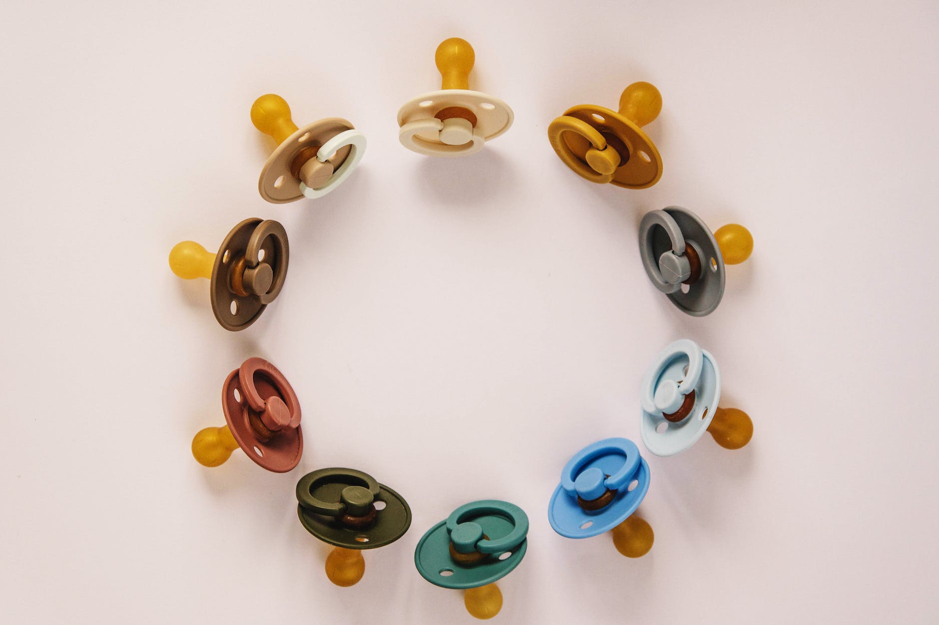 set of multicolored baby pacifiers on table
